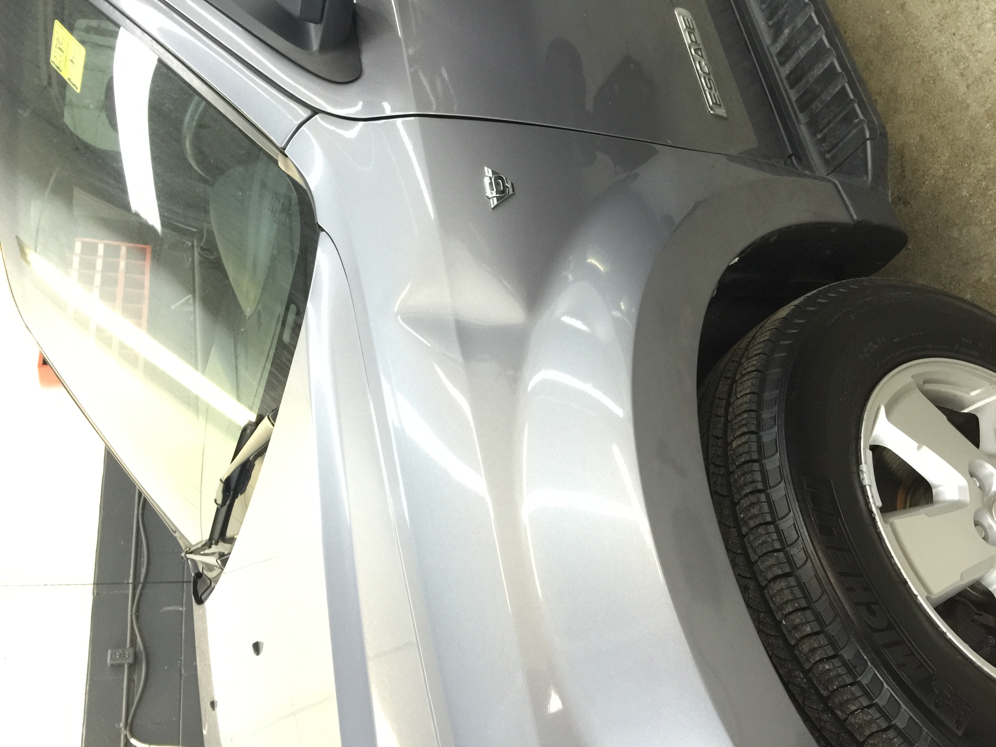 After front fender crease repair on silver SUV